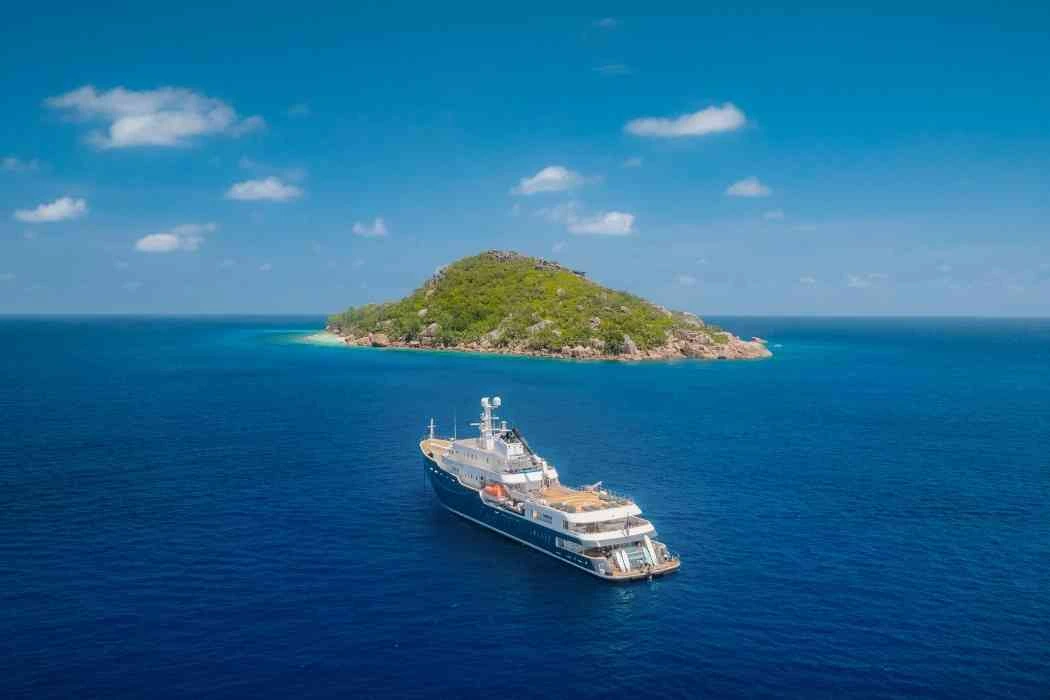 Premium expedition yacht sailing near a tropical island